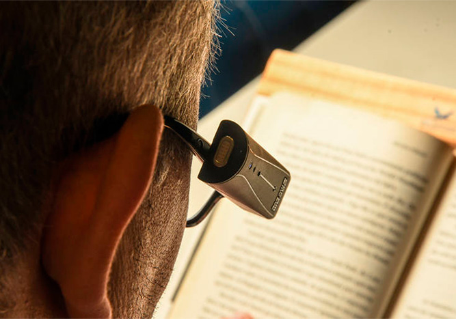 Senhor lendo um livro com o Orcam MyEye